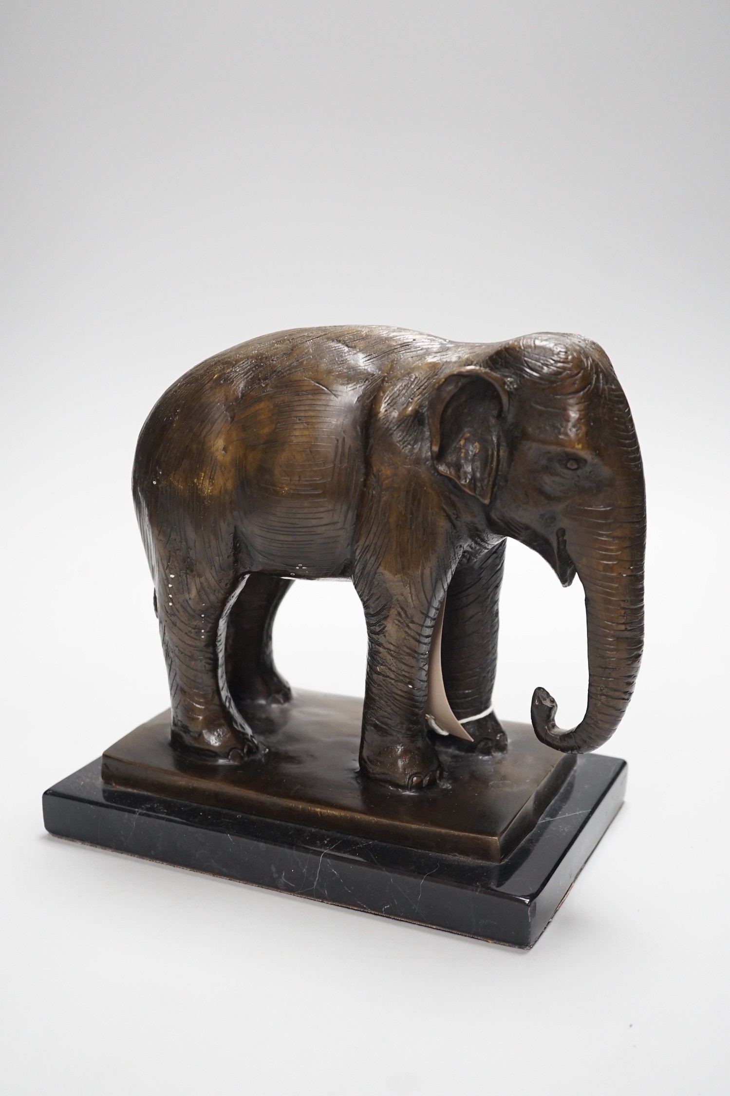 A bronze elephant, on black marble plinth, unsigned, 20cms high
